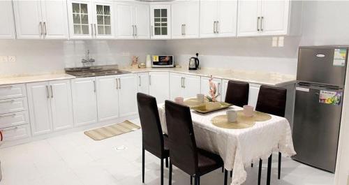 艾卜哈مساكن الدار 1的厨房配有桌椅和冰箱。