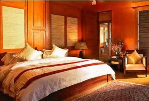 瓜拉丁加奴鲁容码头及度假酒店的一间卧室配有一张大床和一把椅子