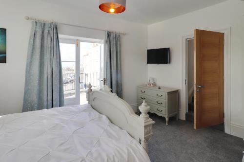 海斯廷斯Master accommodation suite 2 sea view with balcony的卧室配有白色的床和窗户。