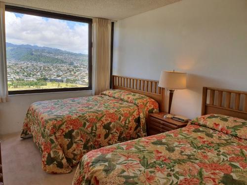 檀香山PonoAloha的酒店客房设有两张床和大窗户。