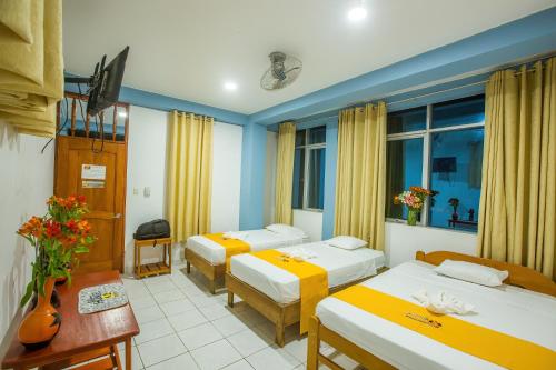 马尔多纳多港Hotel Boulevard的酒店客房设有三张床和窗户。