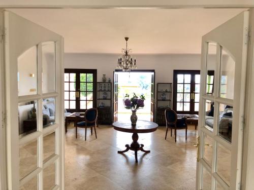EsteponaHuge Golf and Spa Mansion 8 min from Puerto Banus的一间带桌椅的房间和一间用餐室