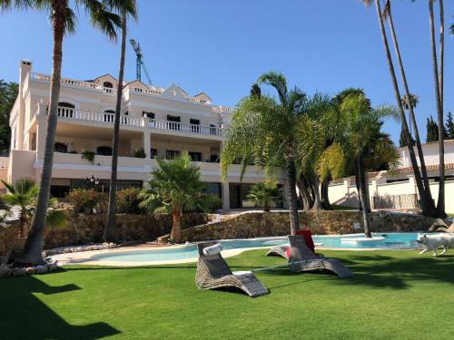 EsteponaHuge Golf and Spa Mansion 8 min from Puerto Banus的游泳池前带两把椅子的度假村