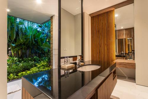 金巴兰阿玛塔别墅酒店的一间带水槽和大窗户的浴室