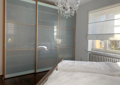 拜罗伊特Apartment am Festspielpark的一间卧室配有衣柜、一张床和一个吊灯