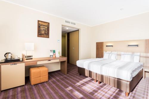 波兹南波兹南德席尔瓦高级酒店的配有一张床和一张书桌的酒店客房