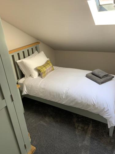 梅尔罗斯The Tweed in the centre of Melrose的一间卧室配有带白色床单和枕头的床。