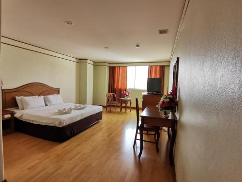 春蓬春蓬莫拉克双子酒店的酒店客房配有一张床铺、一张桌子和一张书桌。