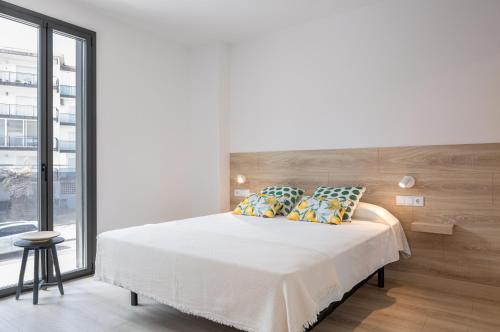 罗萨斯Apartaments La Rosella的白色的卧室设有一张大床和一个窗户