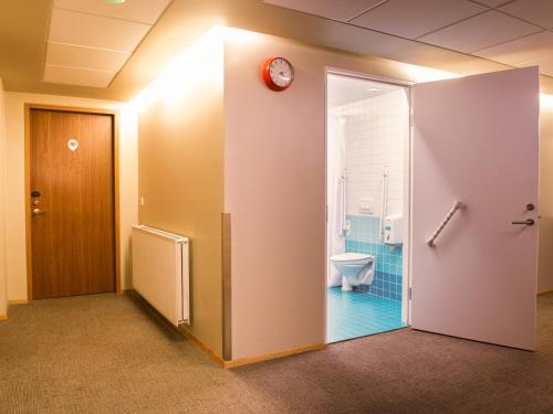 雷克雅未克Loft - HI Eco Hostel的一间带卫生间和墙上时钟的浴室