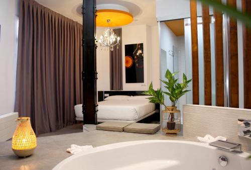 马德里维特翁城市套房的带浴缸的浴室以及带两张床的卧室。