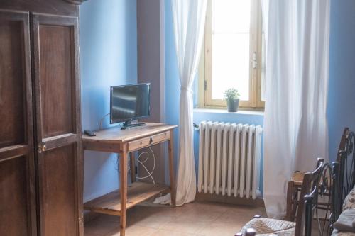 卢切拉Masseria Sant'Agapito的客房设有书桌、电视和窗户。