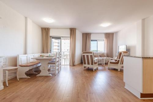 坎布里尔斯Apartamento Vora Mar 33的一个带白色椅子和桌子的沙龙和1间房间