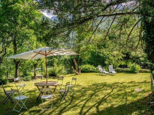 Ala di SturaHoliday Home Villa Biino - VIZ200 by Interhome的院子里的桌子和椅子以及雨伞