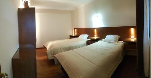 乌尤尼Asian House的酒店客房设有两张床和两盏灯。
