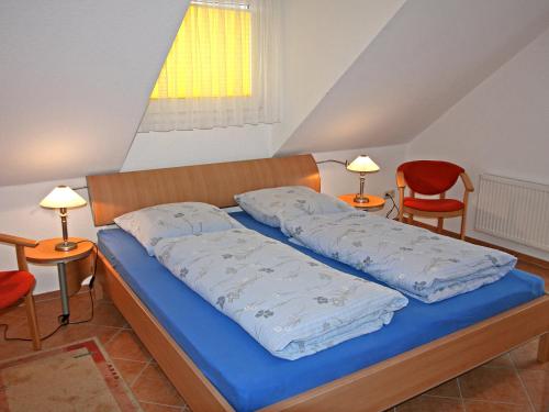 普雷罗Apartment Lemke by Interhome的一间卧室配有一张带蓝色床单的床和两把椅子