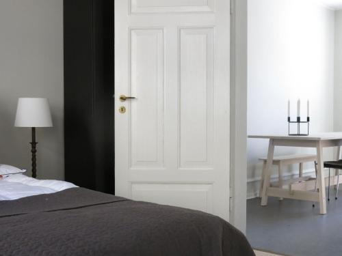 哥本哈根ApartmentInCopenhagen Apartment 1141的卧室设有白色门和桌子