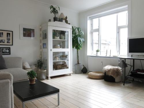 哥本哈根哥本哈根1159公寓的客厅配有白色橱柜和桌子