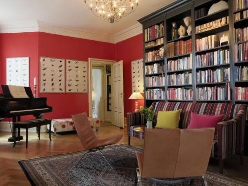 哥本哈根ApartmentInCopenhagen Apartment 1290的客厅设有红色的墙壁和钢琴