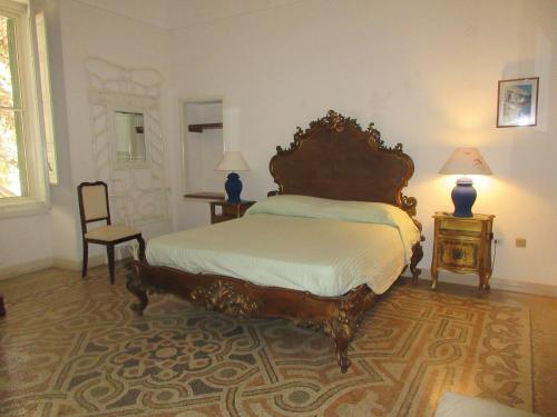 莱乌卡Villa Superior Vista mare的一间卧室配有床和两张桌子及椅子