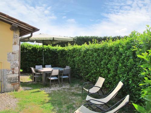 Sant' AlessioHoliday Home Renata by Interhome的庭院配有桌椅和遮阳伞。