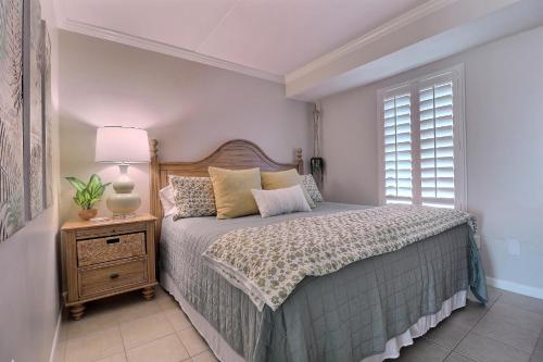 格尔夫海岸Island Winds East的一间卧室配有床、灯和窗户