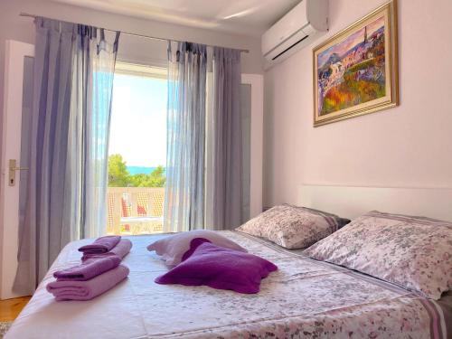 波尔梅里旅馆的一间卧室配有一张带紫色枕头的床