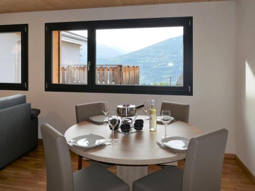SavièseChalet Le Raccard by Interhome的一间带桌椅和窗户的用餐室