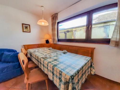 阿尔巴迪卡纳泽伊Apartment Roacia by Interhome的一间带桌子和蓝色沙发的用餐室