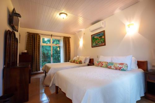 福尔图纳Hotel Eco Arenal的酒店客房设有两张床和窗户。