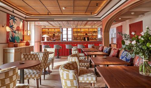 比亚里茨希豪维特酒店的一间带木桌椅的餐厅和一间酒吧