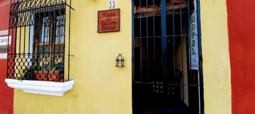 危地马拉安地瓜Hotel Vista al Cerro的黄色的建筑,有窗户和标志