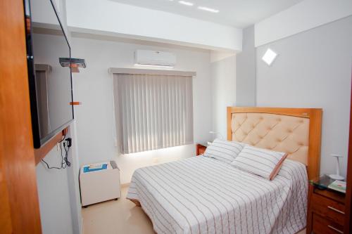亚松森Asuncion Soho - Departamentos的一间卧室配有一张床和一台电视