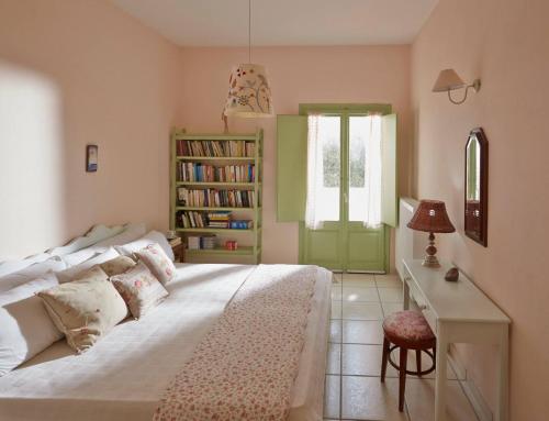 莫诺利索斯Flower and Crafts - The Eco Nature House的一间卧室配有一张床、一张书桌和一个窗户。