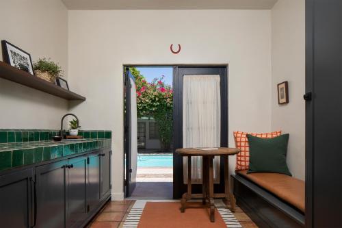 棕榈泉卡萨科迪酒店的厨房配有长凳、桌子和游泳池。