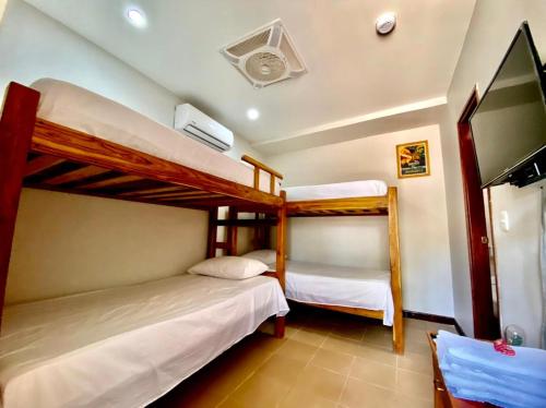 塔甘加Hostal Aurora, Smith Lodging的一间卧室配有两张双层床和一台平面电视