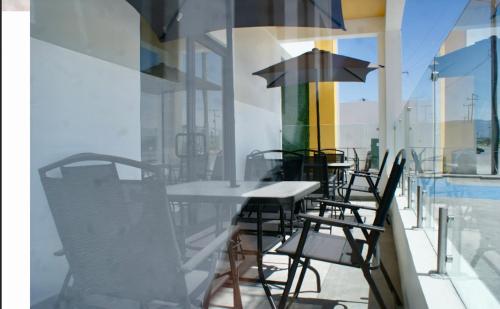 蒙克洛瓦Hotel Capital Frontera的大楼内的桌椅和遮阳伞