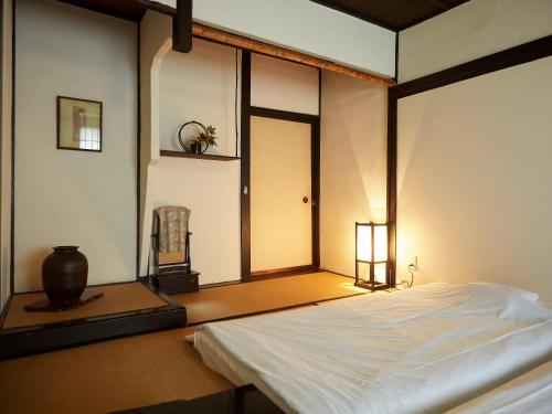 尼崎市竹家庄日式旅馆的卧室配有白色的床和窗户