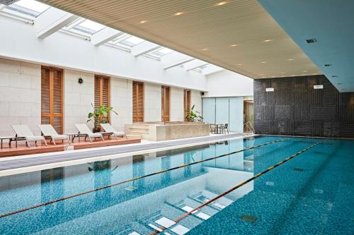 首尔首尔世贸中心奥卓豪景酒店公寓的一个带椅子的大型游泳池和一个游泳池
