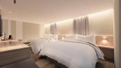 台南大立大饭店的酒店的客房 - 带2张带白色枕头的床