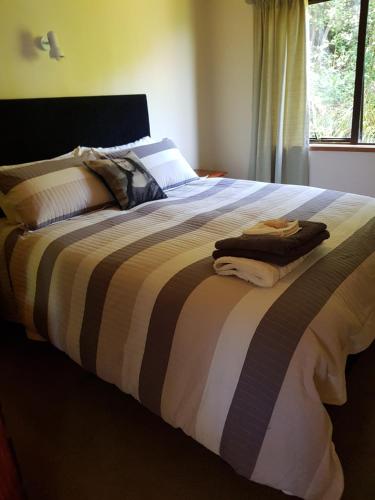 大堡礁岛Awesome View Cottage的一间卧室配有一张带条纹毯子的大床