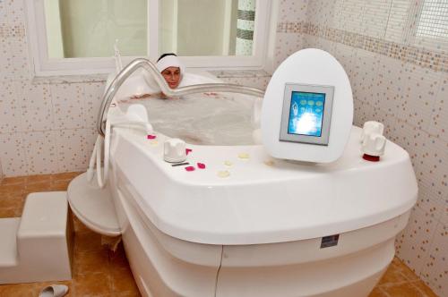 苏塞乐摩纳哥酒店和海水浴的修女坐在浴缸里,电视上