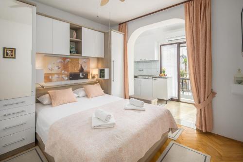 波雷奇卡塔娜公寓别墅酒店的一间卧室配有一张大床和两条毛巾