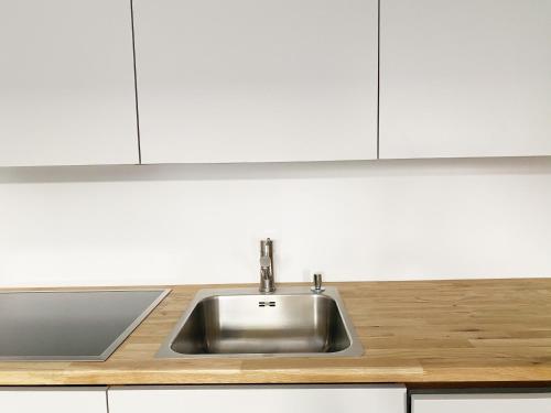 赖兴瑙Haus Münsterblick的一间厨房内的不锈钢水槽,厨房内有白色的橱柜