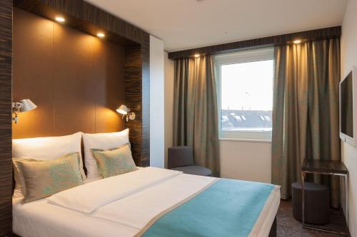 柏林蒂尔加藤1号汽车旅馆的一间卧室设有一张大床和一个窗户。