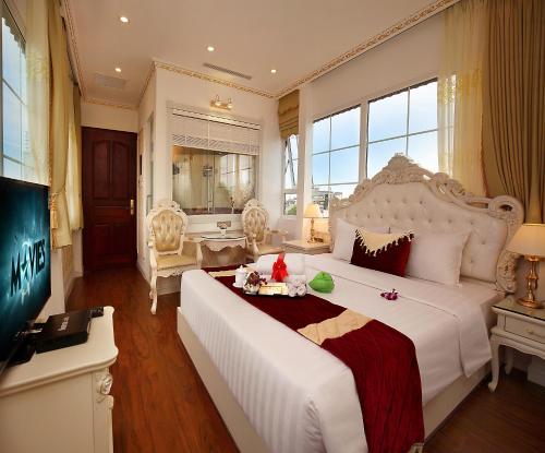 河内Hanoi Hotel Royal的卧室配有一张白色大床和电视。