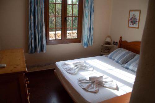 福尔内利斯Homenfun Menorca Playa de Fornells I的一间卧室配有一张床,上面有两条毛巾