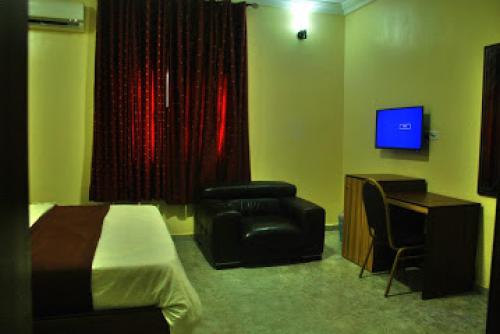 Room in Lodge - Lois Hotel Abuja的电视和/或娱乐中心