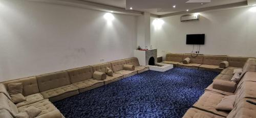 Şulbūkhاستراحة الخير的大型客房设有沙发和平面电视。
