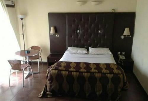 阿沙巴Room in Lodge - Nelrose Hotel, Asaba的一间卧室配有一张大床和一张桌子